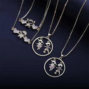 Gold-plated necklaces with cubic zirconia boy and girl pendants on dark background