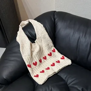 Creamy white knitted tote bag with red heart patterns and hollow crochet detailing