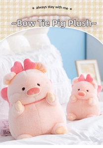 Detail of pink pig plush toy with a cute bow and soft wings on a white bed
