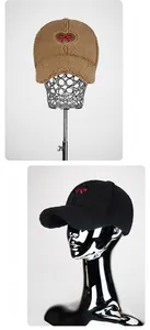 Detail of plush lamb wool baseball caps in black and khaki with red heart embroidery