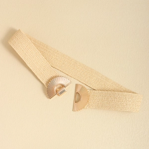 Detail of beige elastic woven waist belt with a golden fan-shaped metal buckle