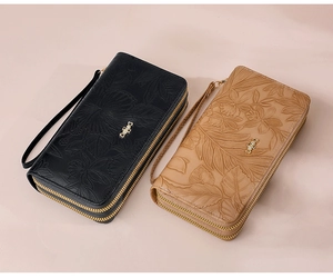 Detail of floral embossed leather long wallets with double zippers and wrist straps
