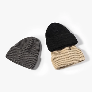Three ribbed knit beanies in dark grey, black, and beige for winter warmth and outdoor style