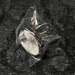 Close-up of a handmade geode crystal ring with silver plating in clear packaging