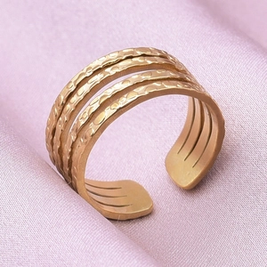 Detailed view of golden adjustable open ring with unique hammered texture on silk