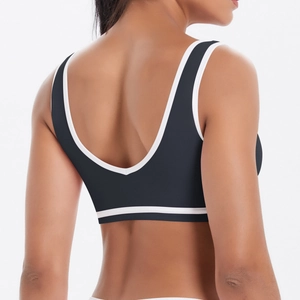 Vue détaillée du soutien-gorge de sport gris foncé avec dos nu en U et passepoil blanc