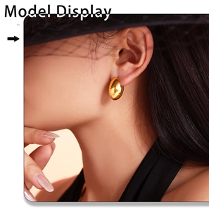 Polished gold oval hoop earrings on model featuring a minimalist vintage french style