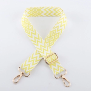 Close-up of yellow and white woven purse strap with geometric diamond patterns and gold buckles