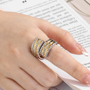 Détail de bague croisée large avec diamants sur main avec fond de papier vintage chic