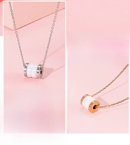 Detail van een roségouden cilinderhanger met wit keramiek inleg en fijne schakelketting