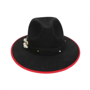 Detailed view of black felt fedora hat with red trim and pearl bead decorations