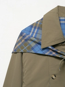 Detail of olive green lapel coat showing resin buttons and blue-brown plaid lining
