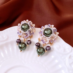 Detail of vintage flower earrings with green resin petals and white pearl drops