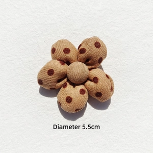 Close-up of 5.5cm padded plaid cotton flower accessory in camel and coffee brown dots