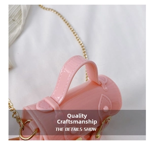 Detailed close-up of pink glossy mini handbag with gold chain strap and metal buckles