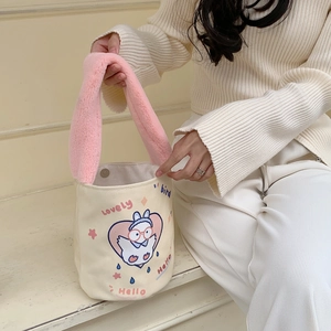 Dettaglio del manico in peluche rosa e stampa di uccelli sulla borsa a secchiello beige