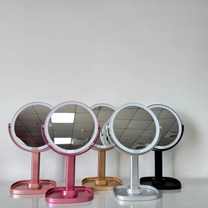 Five LED makeup mirrors in pink, gold, and black with round lighted frames and storage base