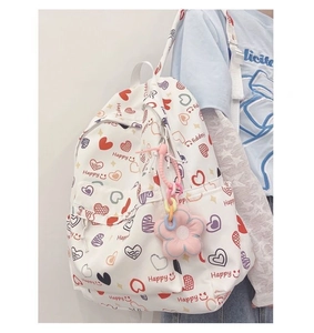 Close-up of heart print backpack with pink flower pendant and Happy letter detail