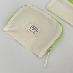 Primer plano de bolsa de viaje de nailon crema con cremallera en verde neón vibrante