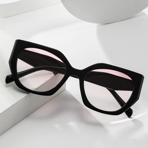 Polygonal oversized sunglasses with black frame and pink gradient lenses on white stone
