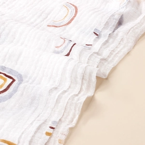 Detailansicht der weichen Textur und des Regenbogenmusters eines Baby-Mulltuchs aus Baumwolle