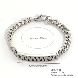 Detail view of a silver stainless steel Cuban link bracelet with textured M-pattern plate