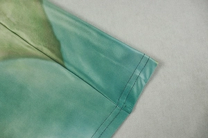 Detail of teal gradient fabric showing precise double-needle stitching and texture