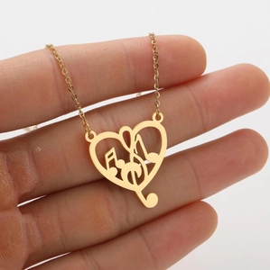 Close-up of golden heart-shaped necklace featuring an inner musical note charm detail