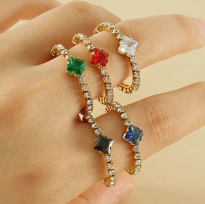 Close-up of adjustable gold-plated rings set with colorful square-cut cubic zirconia