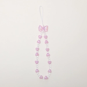 Pink bow and heart beaded wrist strap phone charm with transparent beads on white background