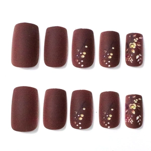 Vue détaillée de faux ongles bordeaux mats avec des motifs floraux automnaux peints à la main