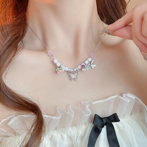 Close-up of a sweet butterfly beaded necklace with colorful flowers and pearls on a model