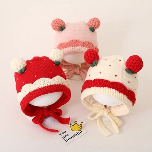 Detailweergave van gebreide babymutsen met oorkleppen en pompons in diverse kleuren