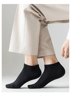 Detail of black breathable cotton crew socks paired with beige trousers and modern shoes
