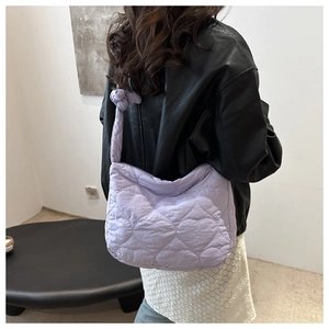 Detail of light purple quilted tote bag with heart patterns and knotted shoulder strap