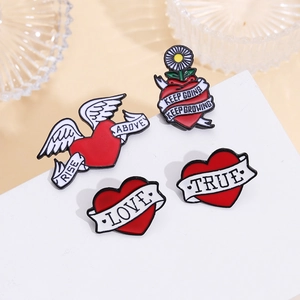 Detail of four red heart enamel pins featuring inspirational quotes and retro illustrations