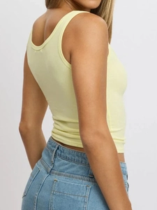 Detail view of light yellow slim fit button vest paired with high waist denim shorts
