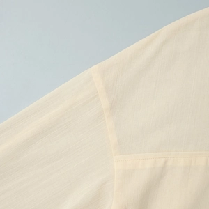 Detailed close-up of light beige linen-blend shirt showing fine stitching and fabric texture