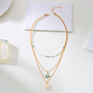 Collier doré multicouche avec perles blanches, étoile de mer bleue et pendentif coquillage