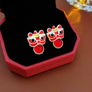 Close-up of red enamel lion dance earrings with red beads in a gift box for Chinese New Year