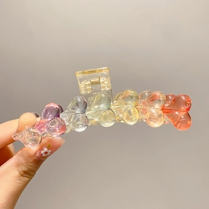 Detail of a transparent gradient heart-shaped hair claw clip made of acrylic material
