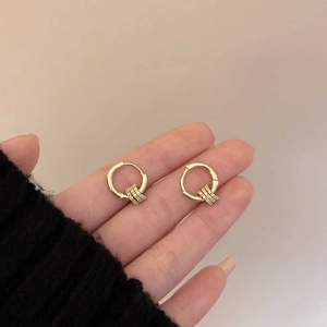 Close-up of 18k gold plated hoop earrings with sparkling zircon dangles held by hand