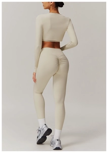 Rear view of beige long-sleeve crop top and scrunch butt yoga leggings workout set