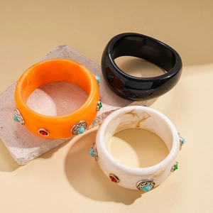 Three-piece bohemian resin bangles set with turquoise and crystal inlays on stone stand