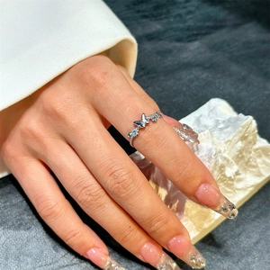 Close-up of butterfly ring with light blue crystals and twisted rope band texture