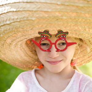 Gros plan d'une fille souriante portant des lunettes de fête piment mexicain rouge