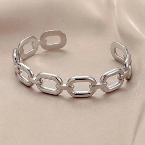 Chunky silver stainless steel chain link open bangle on luxury satin background
