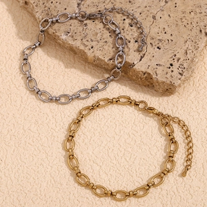Detail of adjustable gold and silver plated chain with link clasp on textured stone