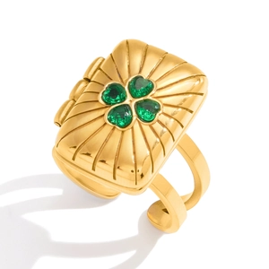 Close-up of gold square photo ring with green clover pattern and sunburst texture