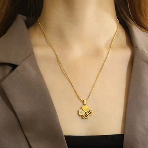 Gold clover necklace with hollow heart and diamond-set petal on a stainless steel chain
